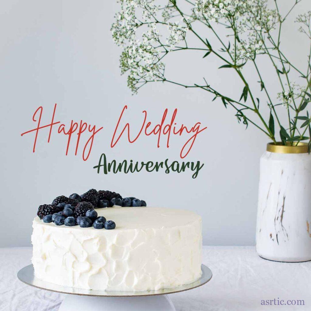 A picture of a delicious white, creamy cake topped with blackberries and placed on a decorative flower vase is accompanied by an anniversary card.