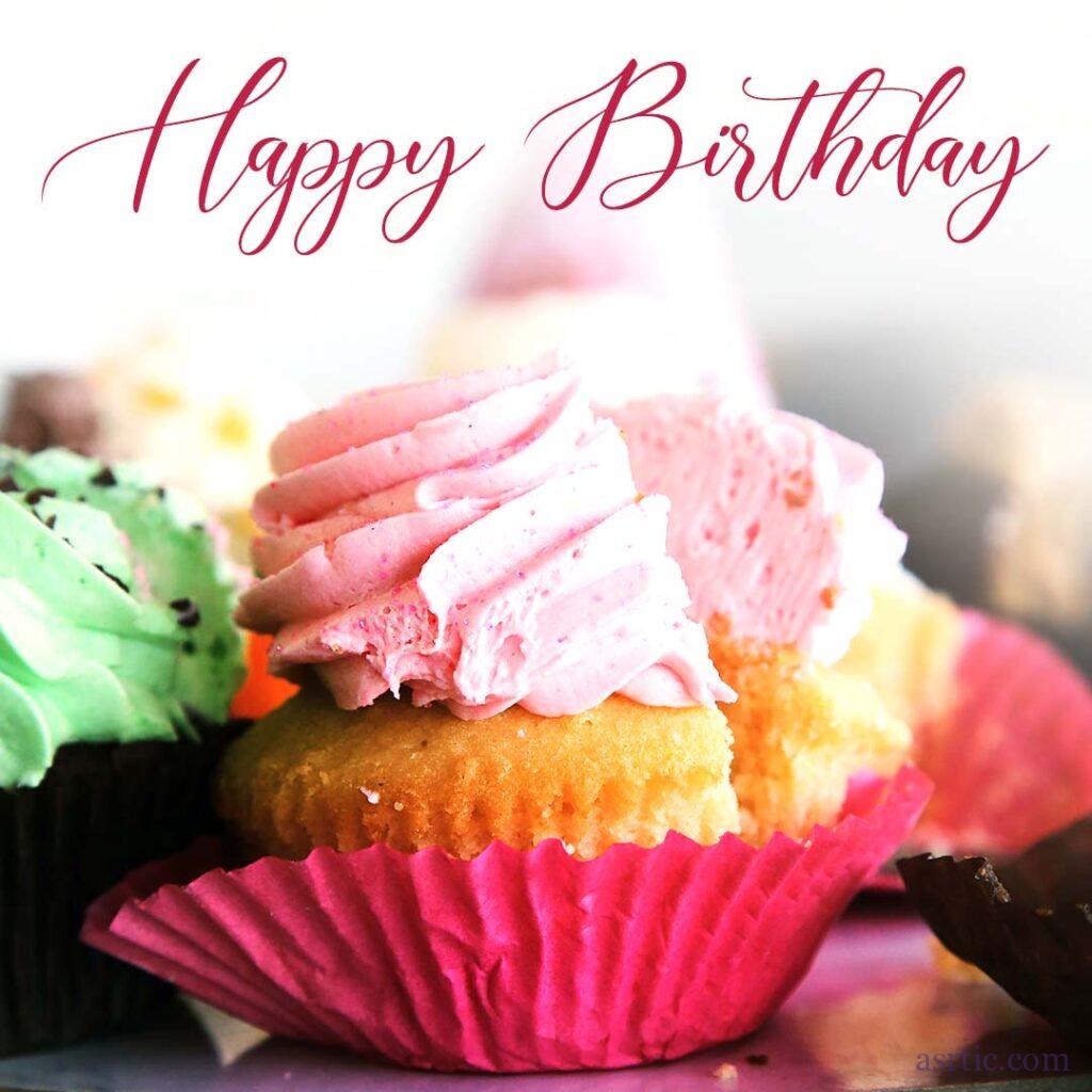 A close-up of a vanilla cupcake with a Happy Birthday greeting written